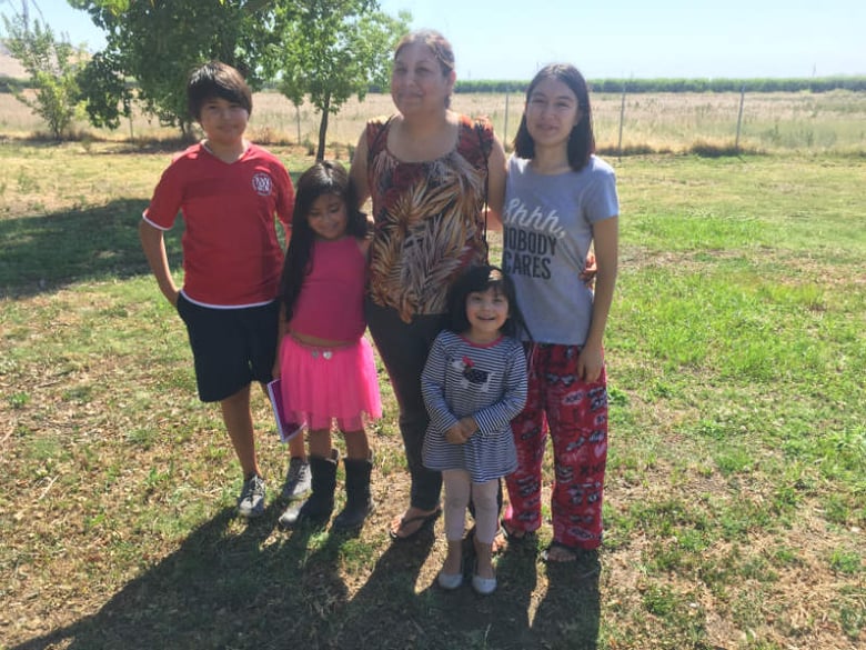Claudia Angulo stands with her four children outside their home in Orange Cove, California. Angulo says her son Isaac was exposed to toxic levels of the pesticide chlorpyrifos while she was pregnant with him.